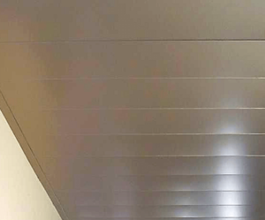 коридорный потолок Modern interior corridor with sleek metallic ceiling and neutral-toned walls.