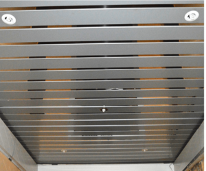 кормдорный потолок Modern interior with sleek metallic ceiling, brushed steel slats, and recessed LED lights.